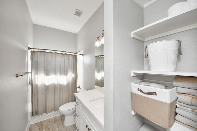 bathroom featuring a shower with shower curtain, visible vents, vanity, and toilet