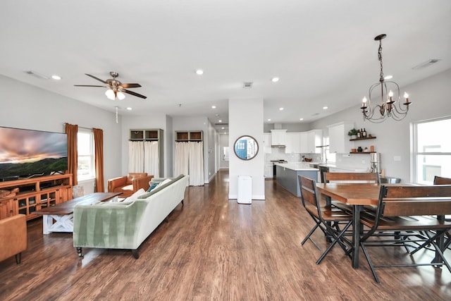 dining area with dark wood-style floors, ceiling fan with notable chandelier, and recessed lighting