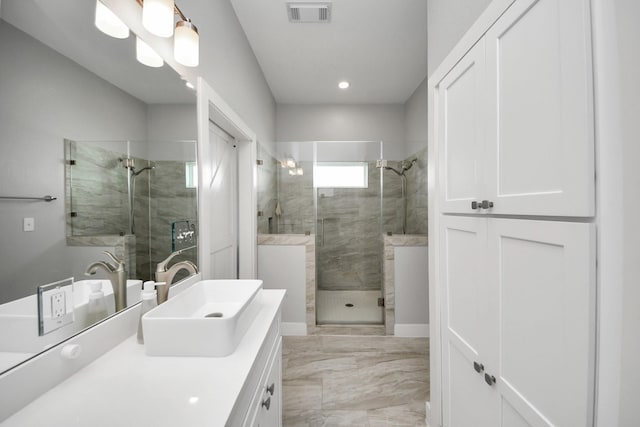 bathroom featuring a stall shower, vanity, and visible vents