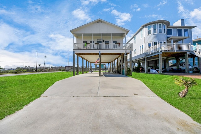 beach home with driveway, stairs, a front lawn, and a carport