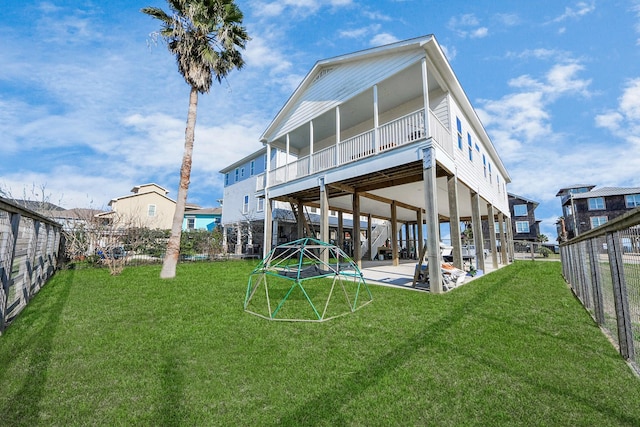 rear view of property featuring a patio area, a lawn, and a fenced backyard