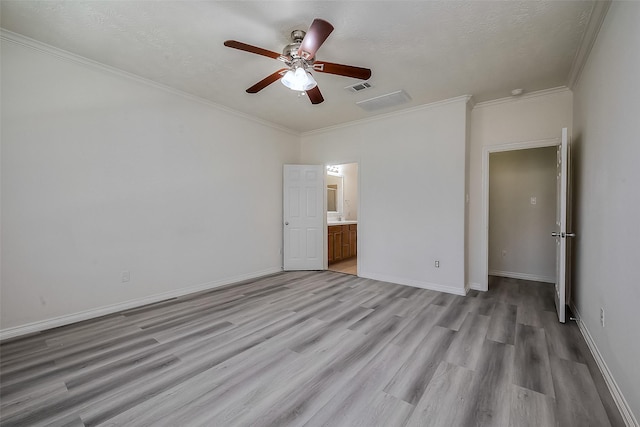 unfurnished bedroom featuring ornamental molding, light wood finished floors, visible vents, and baseboards