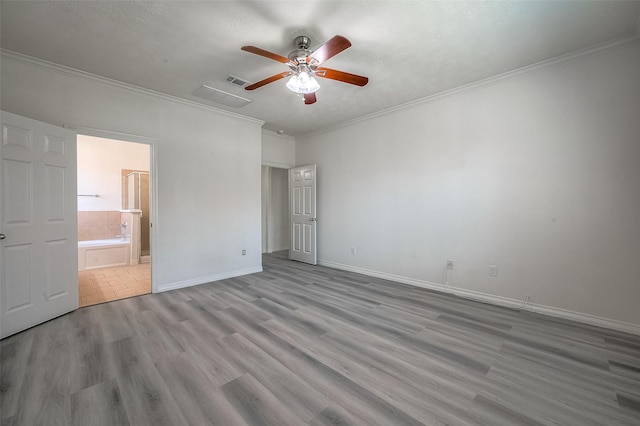 unfurnished bedroom featuring visible vents, crown molding, baseboards, and wood finished floors