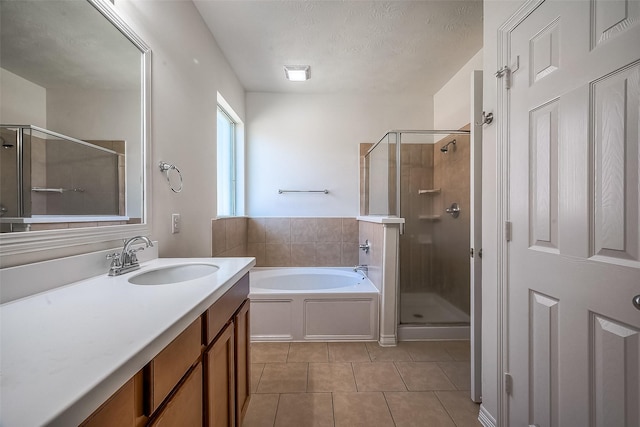 bathroom featuring tile patterned flooring, a textured ceiling, vanity, a shower stall, and a bath