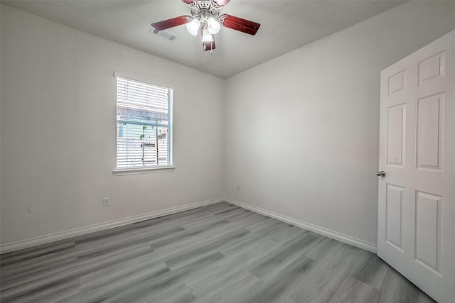 unfurnished room featuring baseboards, ceiling fan, visible vents, and light wood-style floors