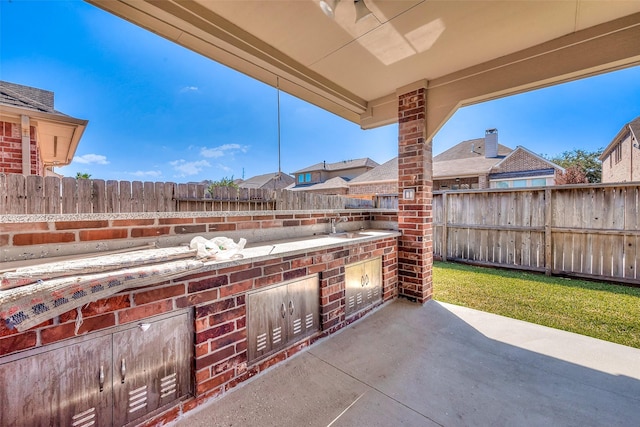 view of patio with a sink and a fenced backyard