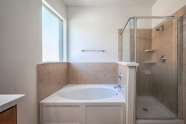 bathroom featuring a shower stall, vanity, and a bath