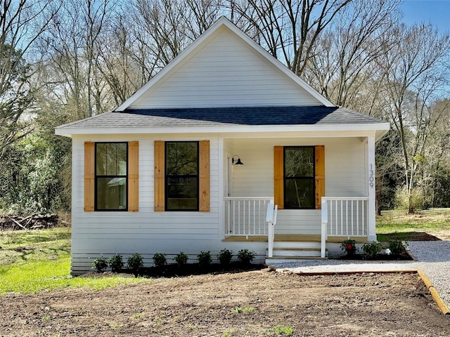 bungalow-style home featuring covered porch and roof with shingles