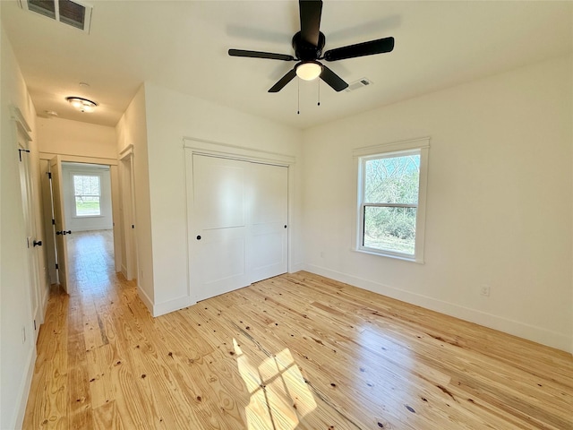 unfurnished bedroom with light wood-style floors, visible vents, and baseboards