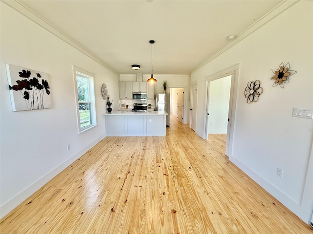 interior space with light wood finished floors, baseboards, and ornamental molding