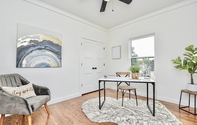 home office with ornamental molding, light wood-style floors, a ceiling fan, and baseboards