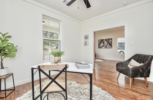 office space with wood finished floors, visible vents, baseboards, a ceiling fan, and crown molding