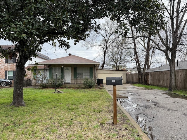 bungalow-style home with a garage, a front lawn, a porch, and fence