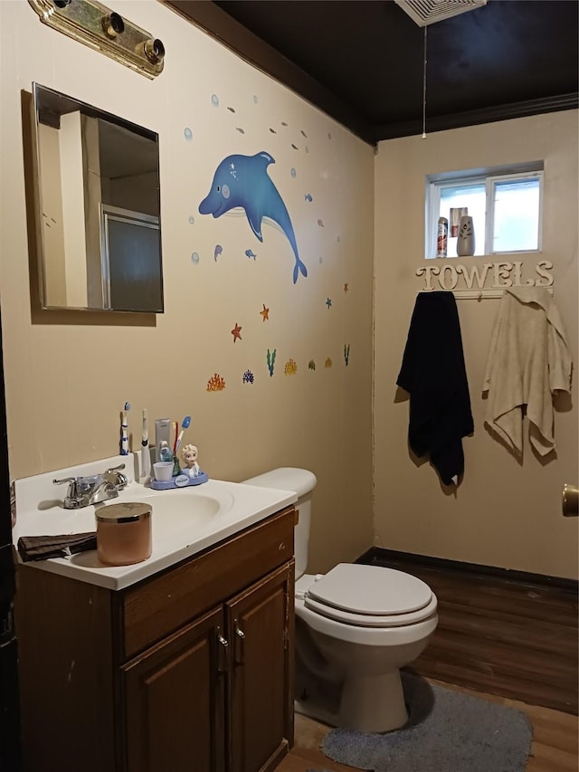 bathroom with wood finished floors, vanity, and toilet