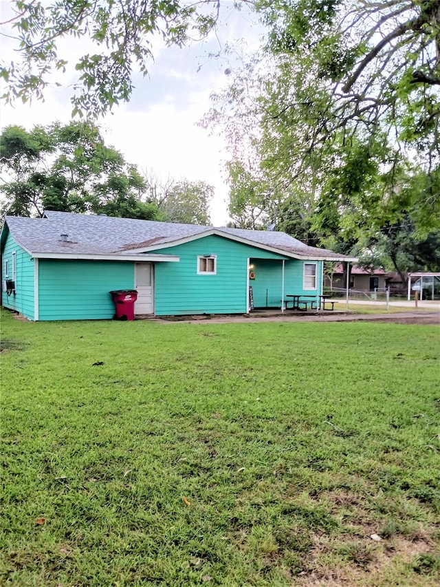 rear view of property featuring a lawn