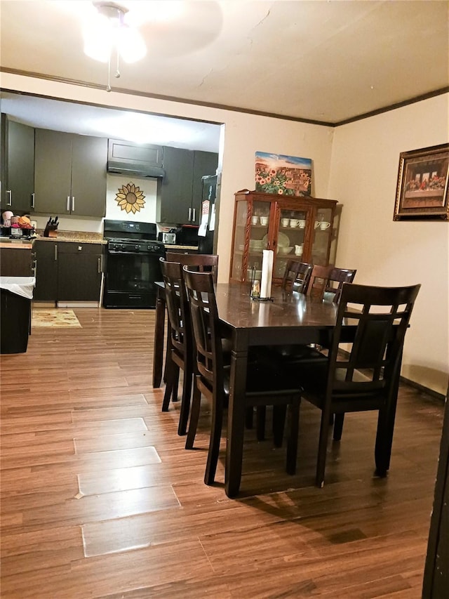 dining space with light wood-type flooring and crown molding