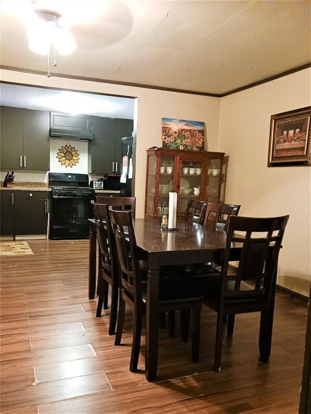 dining space featuring ornamental molding and wood finished floors