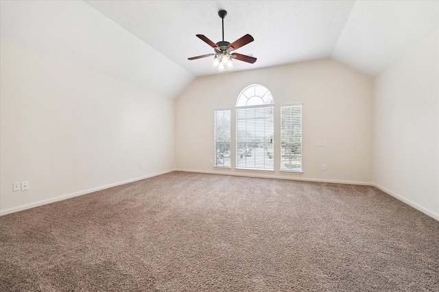 carpeted spare room with lofted ceiling, a ceiling fan, and baseboards