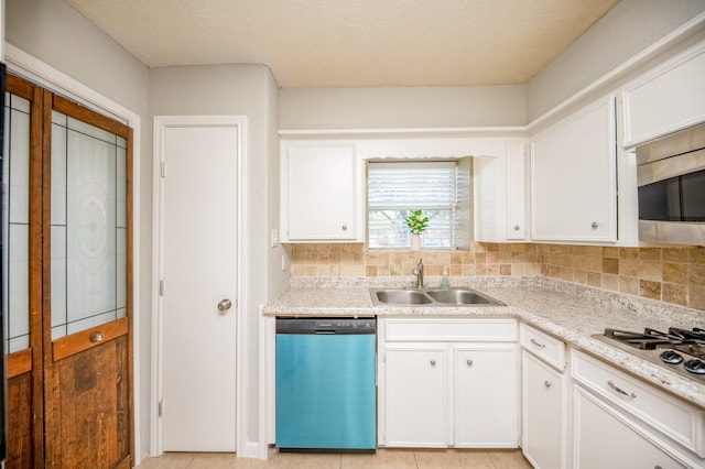 kitchen featuring tasteful backsplash, appliances with stainless steel finishes, white cabinets, and a sink