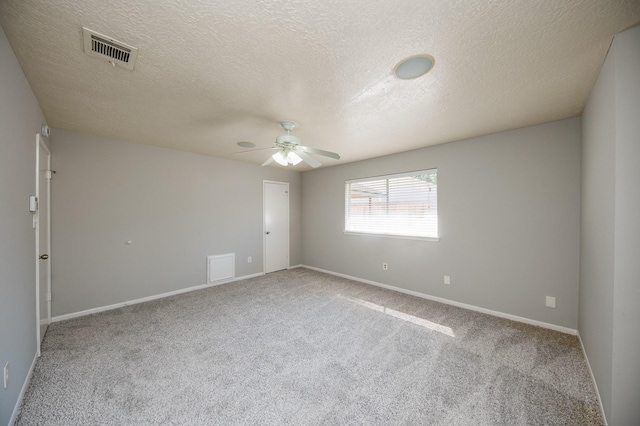 unfurnished room with a textured ceiling, carpet flooring, visible vents, baseboards, and a ceiling fan