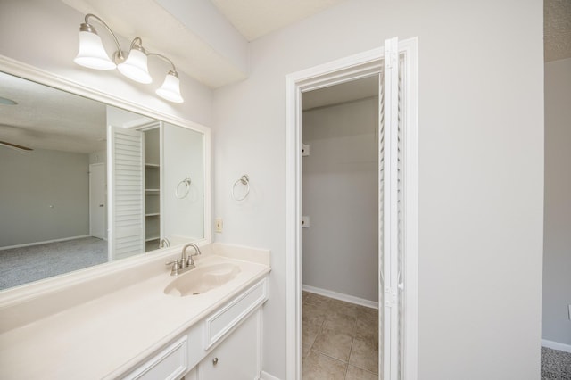 bathroom featuring tile patterned flooring, vanity, and baseboards