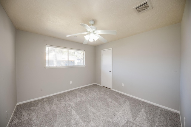 unfurnished room featuring a textured ceiling, carpet floors, visible vents, and baseboards