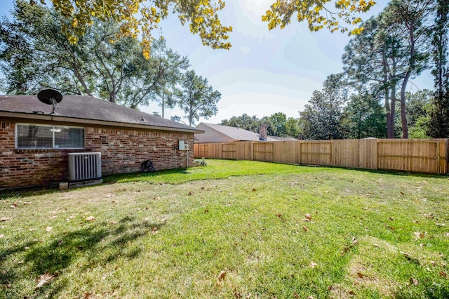 view of yard featuring fence and central air condition unit