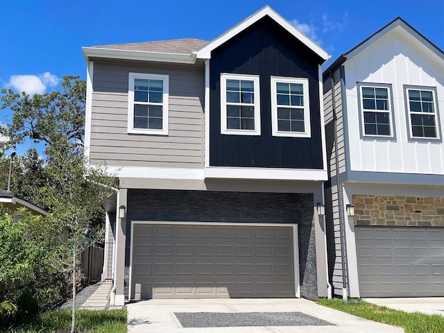 view of front of house with a garage, stone siding, and board and batten siding