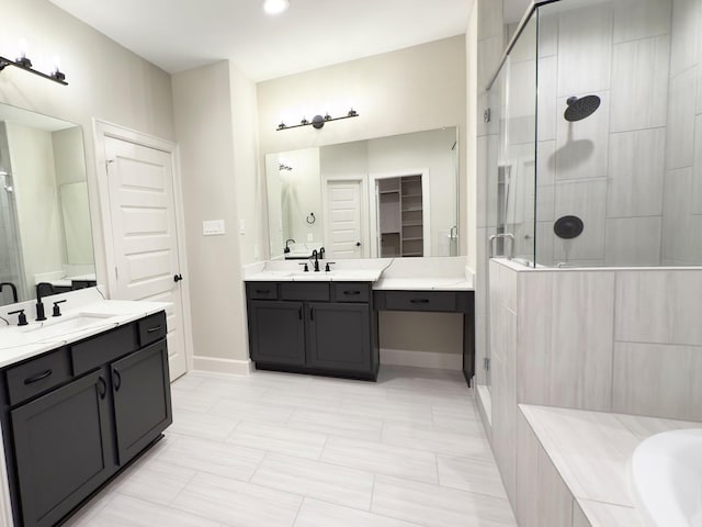 bathroom with a stall shower, baseboards, two vanities, a sink, and a bath