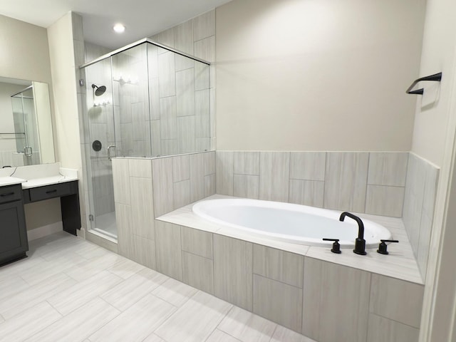 bathroom with a stall shower, a garden tub, and vanity