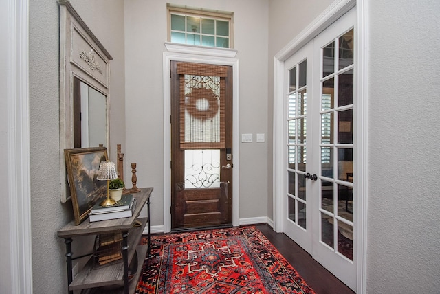 foyer entrance with a healthy amount of sunlight, baseboards, dark wood-type flooring, and french doors