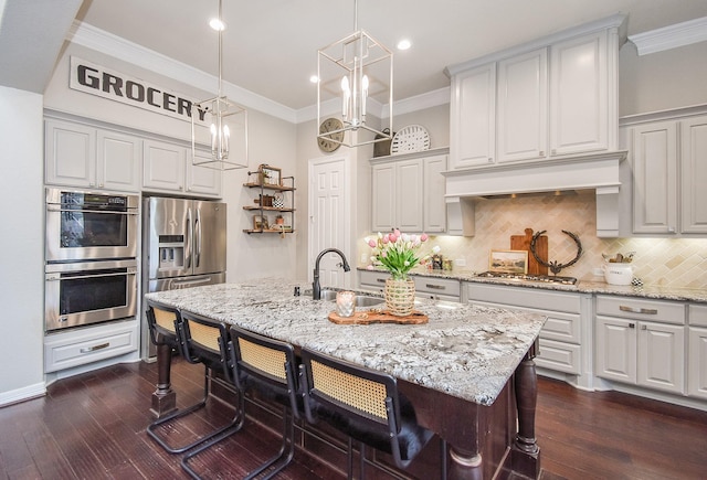 kitchen with appliances with stainless steel finishes, dark wood-type flooring, a sink, and ornamental molding