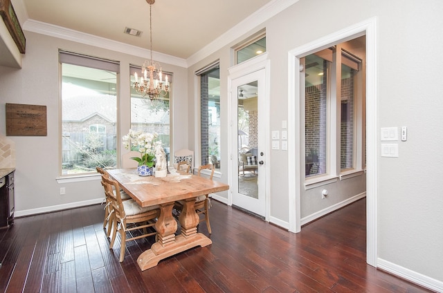 dining space featuring dark wood-style floors, baseboards, ornamental molding, and an inviting chandelier