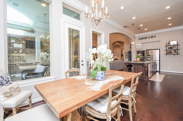 dining room featuring arched walkways, crown molding, visible vents, an inviting chandelier, and dark wood-type flooring