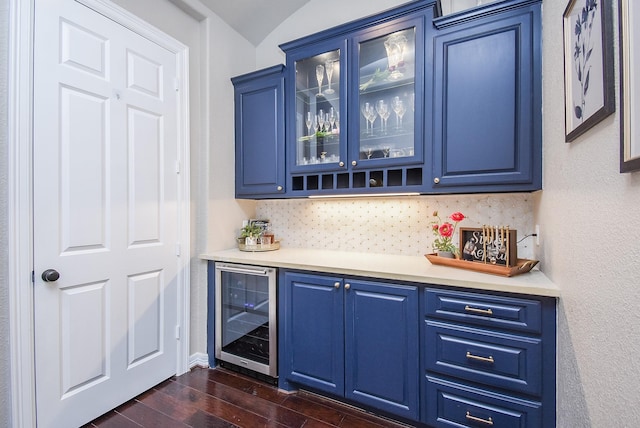 bar featuring a dry bar, beverage cooler, decorative backsplash, lofted ceiling, and dark wood-style floors