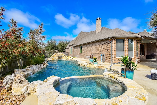 view of swimming pool with a pool with connected hot tub, a fenced backyard, and a patio