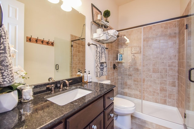 bathroom featuring a stall shower, vanity, toilet, and tile patterned floors