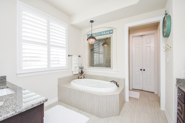 bathroom featuring a garden tub and vanity