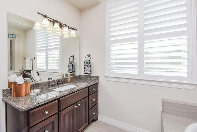 bathroom with wood finished floors, vanity, and baseboards