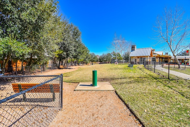 view of home's community with a yard and fence