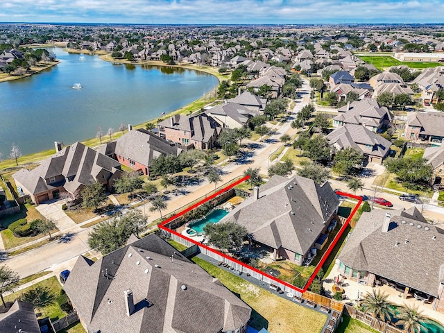 drone / aerial view featuring a residential view and a water view