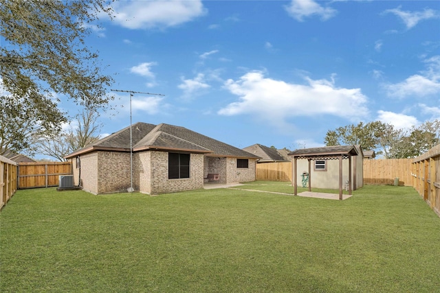 back of house featuring a patio, a fenced backyard, central air condition unit, brick siding, and a yard