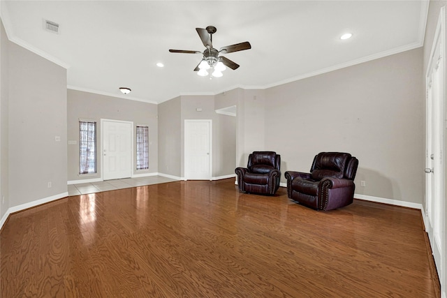 sitting room with baseboards, crown molding, visible vents, and wood finished floors