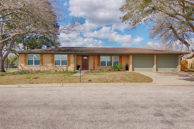 single story home with an attached garage, brick siding, driveway, and a front yard