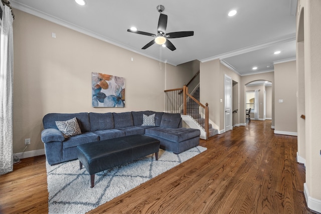 living area with arched walkways, recessed lighting, wood finished floors, baseboards, and stairs