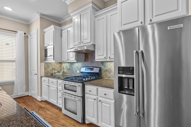 kitchen with appliances with stainless steel finishes, crown molding, light wood-type flooring, under cabinet range hood, and white cabinetry