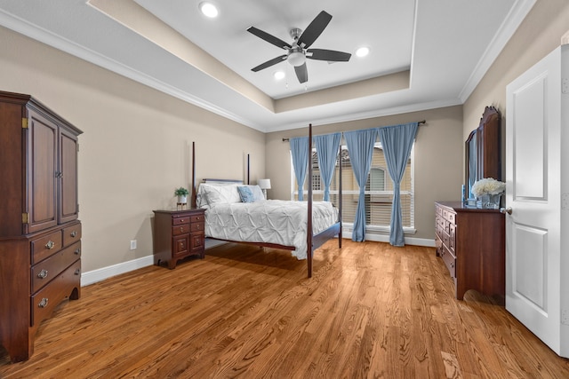 bedroom featuring recessed lighting, baseboards, ornamental molding, light wood finished floors, and a raised ceiling