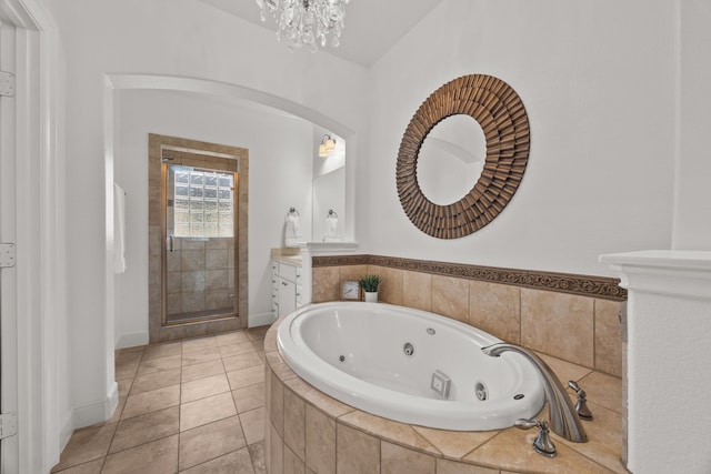 full bath featuring tile patterned flooring, vanity, a shower stall, a tub with jets, and an inviting chandelier