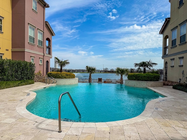 pool with a water view and a patio