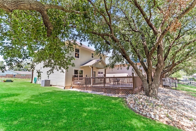 back of property with fence, a deck, central AC, and a yard